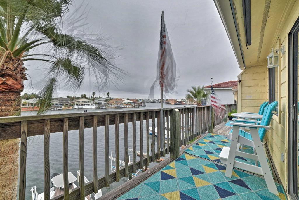 un porche con una silla azul y el agua en Canalfront Retreat with Dock, Hot Tub and Pool Access!, en Corpus Christi