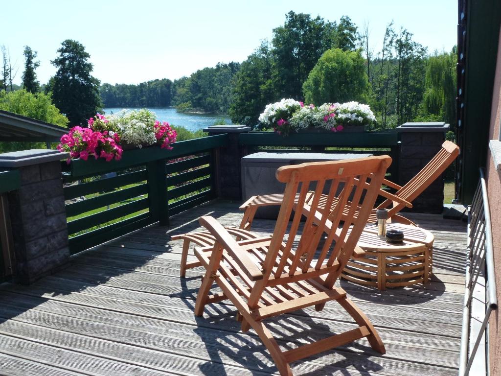 zwei Schaukelstühle auf einer mit Blumen bestückten Terrasse in der Unterkunft Seeblick Kemnitz in Werder