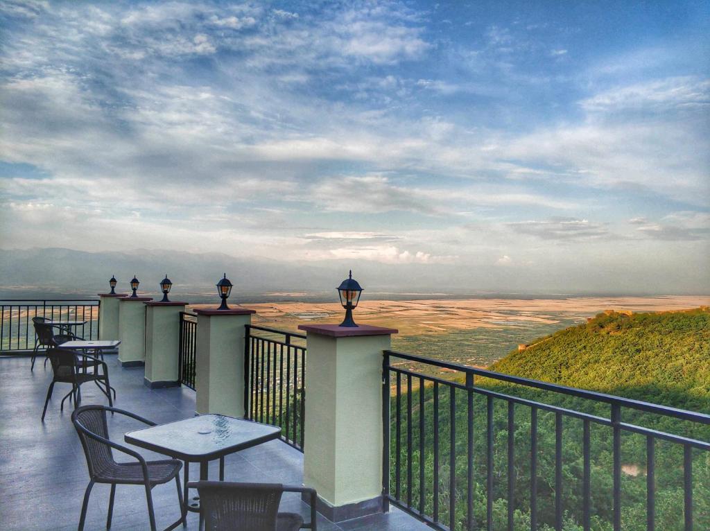 a balcony with tables and chairs and a view of the desert at Favourite in Sighnaghi