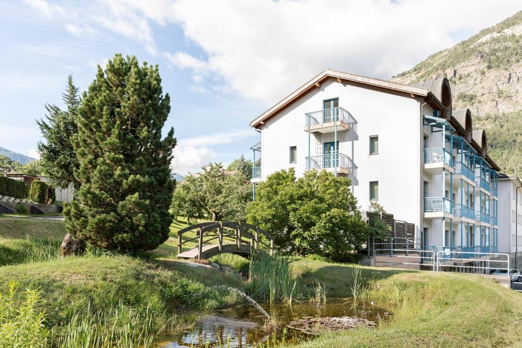 a building with a pond in front of it at Hotel & Bildungshaus St. Jodern in Visp