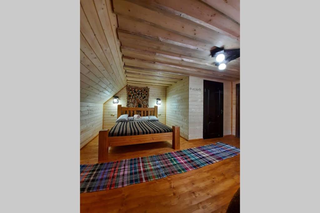 een slaapkamer met een bed en een houten plafond bij Номер 6 Садиба У Ані in Synevyrsʼka Polyana