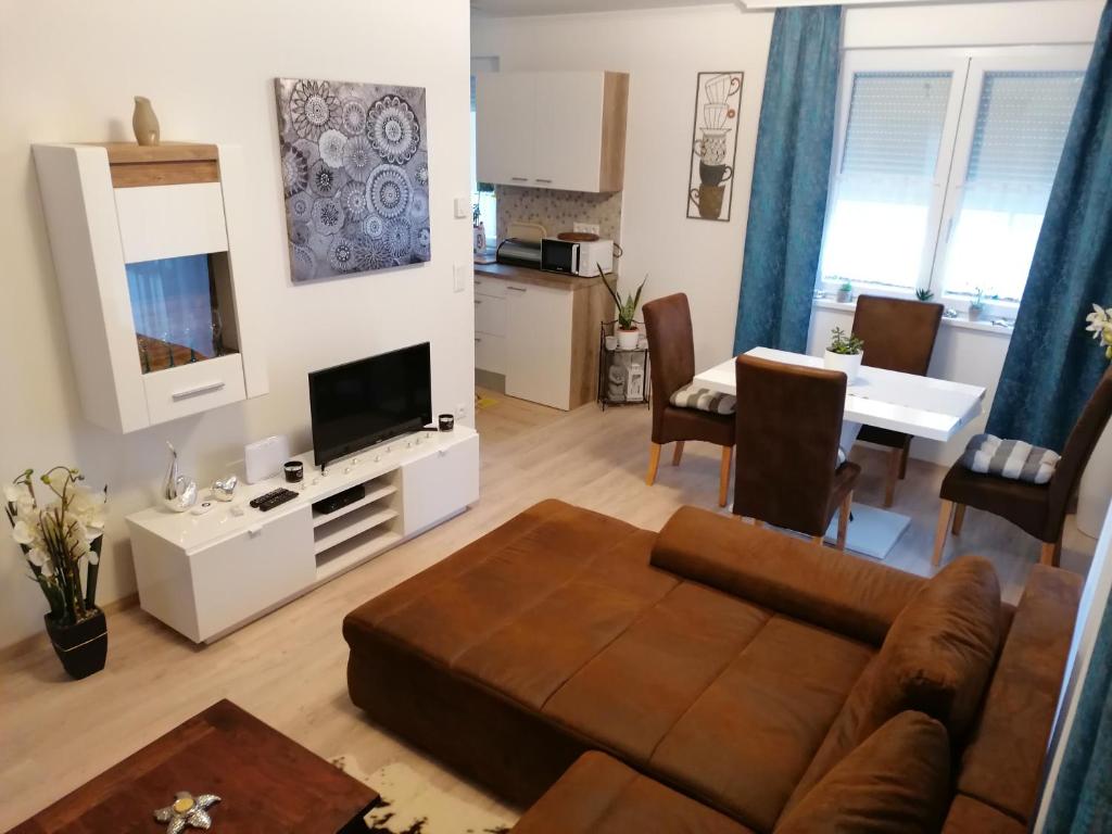uma sala de estar com um sofá e uma mesa em Relax Prémium Wellness Apartman em Siófok