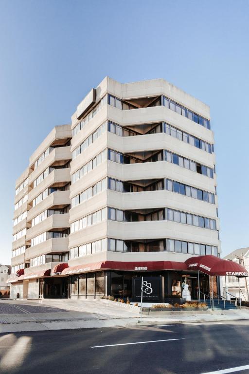 un edificio blanco alto con un restaurante frente a él en Stamford Suites, en Stamford