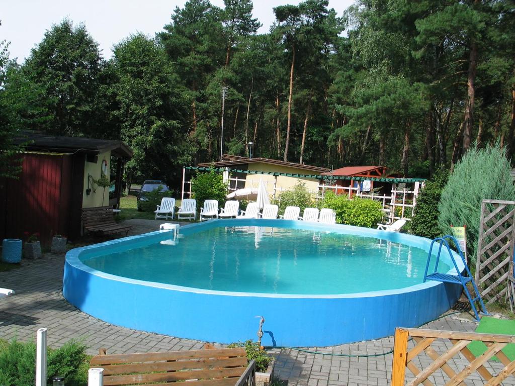 a swimming pool with a fence and a house at Ośrodek Wypoczynkowy Jelonek in Wolsztyn
