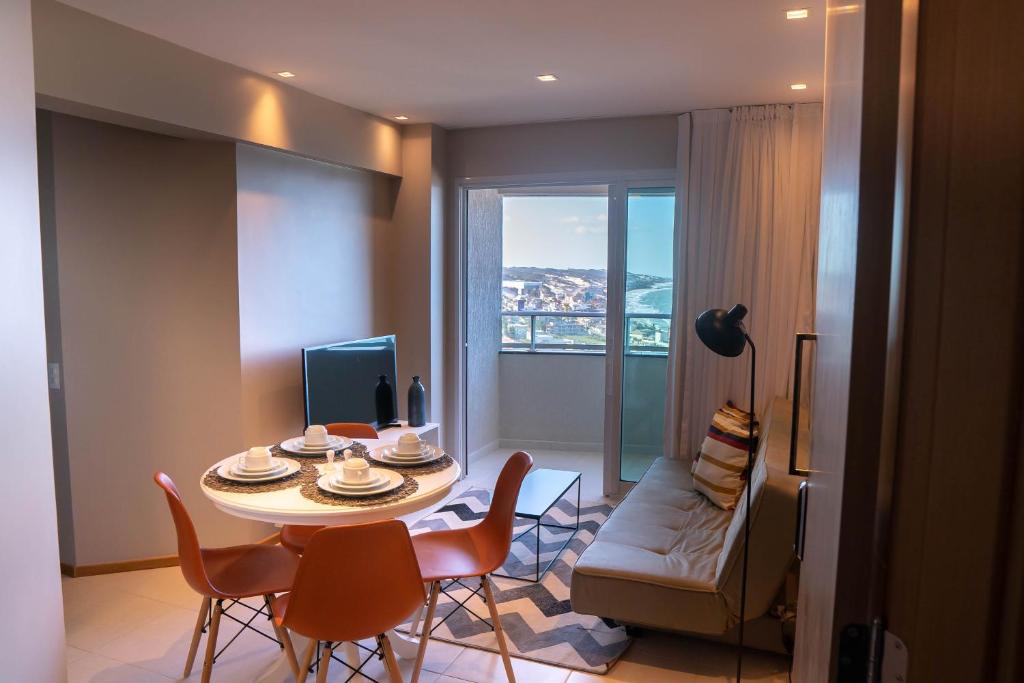 uma sala de estar com uma mesa e cadeiras e uma janela em Riviera - 1204 em Natal