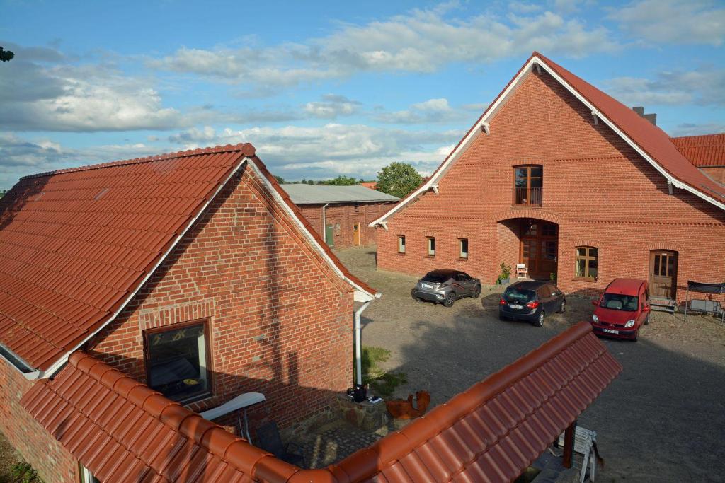 a large brick building with cars parked in a parking lot at Hof Brinker - Haffblick in Boiensdorf