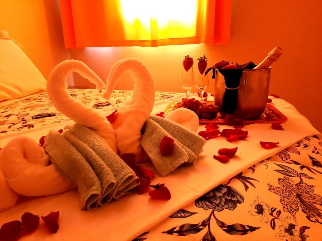 two towels and hearts are on a bed at Hospedagem D´Roos in Canela