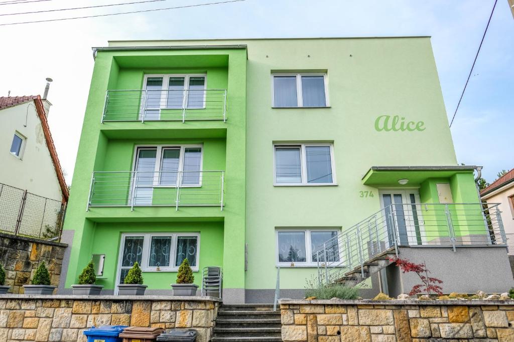 une maison verte avec des escaliers en face de celle-ci dans l'établissement Vila Alice, à Luhačovice