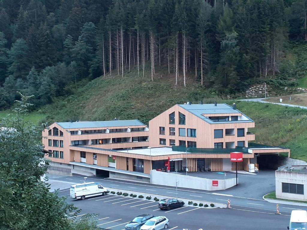 a building with a parking lot in front of a mountain at Sellrain apartment in Sellrain