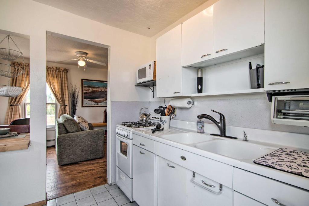 una cocina con armarios blancos y fregadero en Red Gates Cottage 3 Miles to University! en Laramie