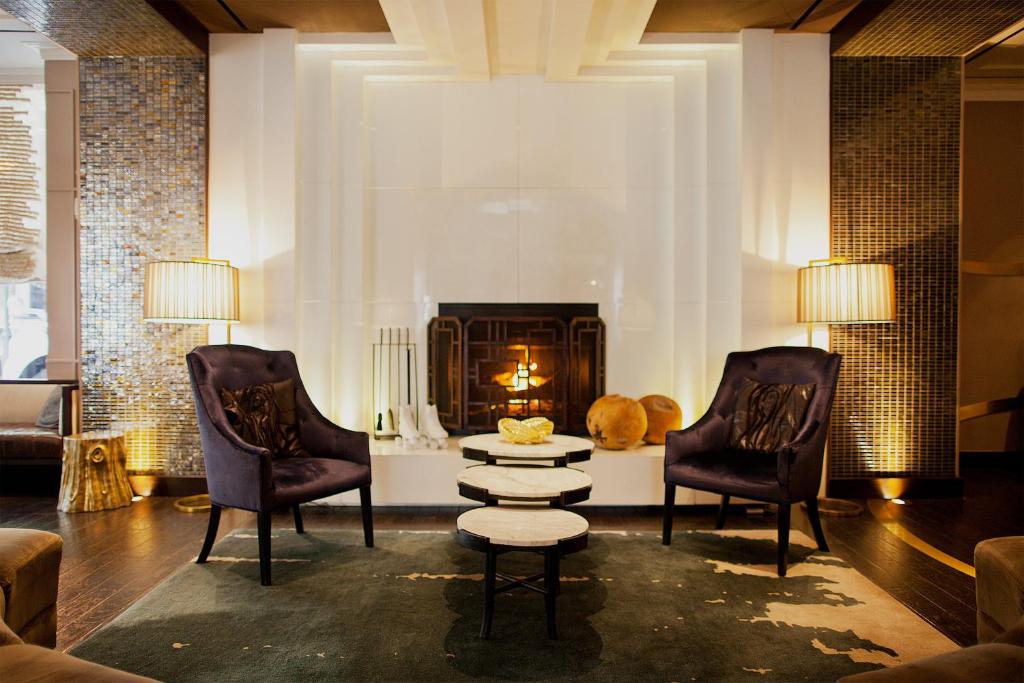 a living room with two chairs and a fireplace at Kimpton Hotel Palomar Philadelphia, an IHG Hotel in Philadelphia