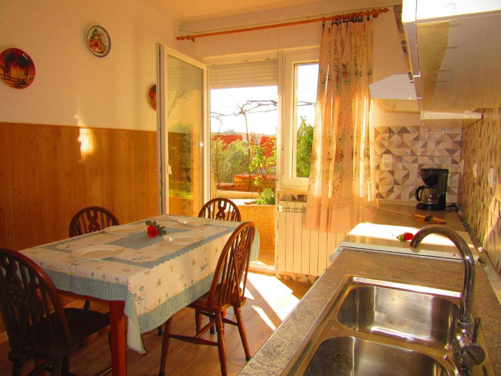 kuchnia ze stołem, stołem i zlewem w obiekcie Two-Bedroom Apartment in Pula XI w mieście Veruda