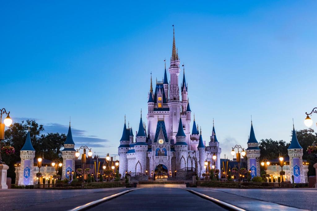 a disney castle is lit up at night at Holiday Inn Express & Suites S Lake Buena Vista by IHG in Kissimmee