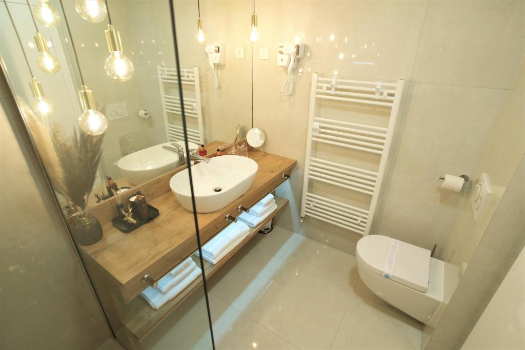 uma casa de banho com um lavatório, um WC e um espelho. em Apartman My Story em Osijek