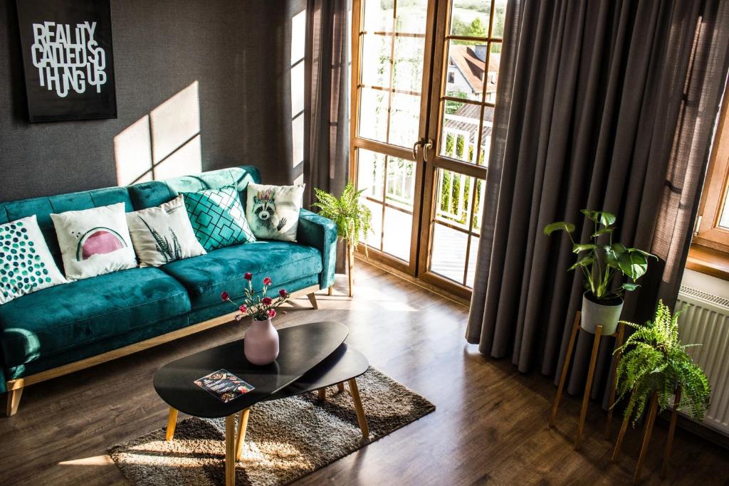 a living room with a blue couch and a table at Pod Kolumnami in Pilica