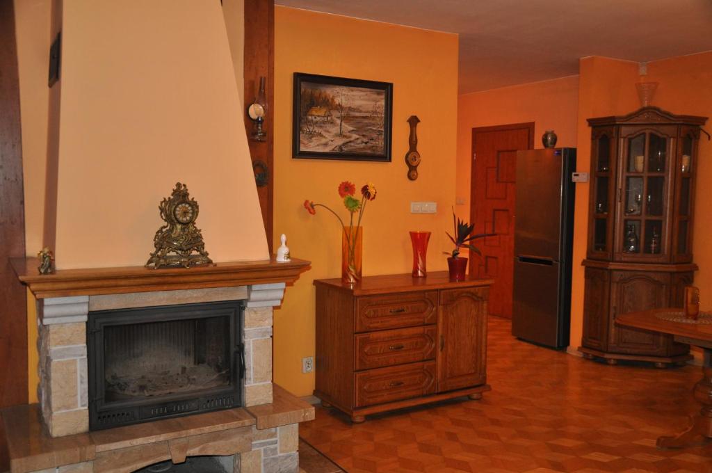 uma sala de estar com uma lareira e um frigorífico em Dworek - Polna em Skrzeszew