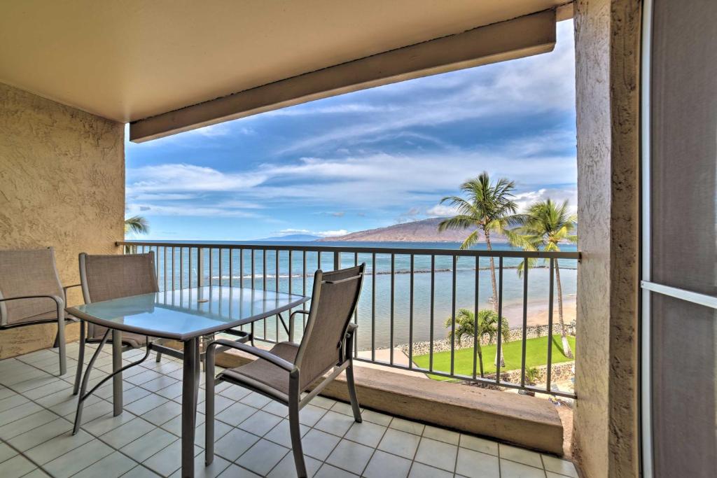 a balcony with a table and chairs and a view of the ocean at Beachfront Kihei Sanctuary with Lanai and Ocean Views! in Kihei