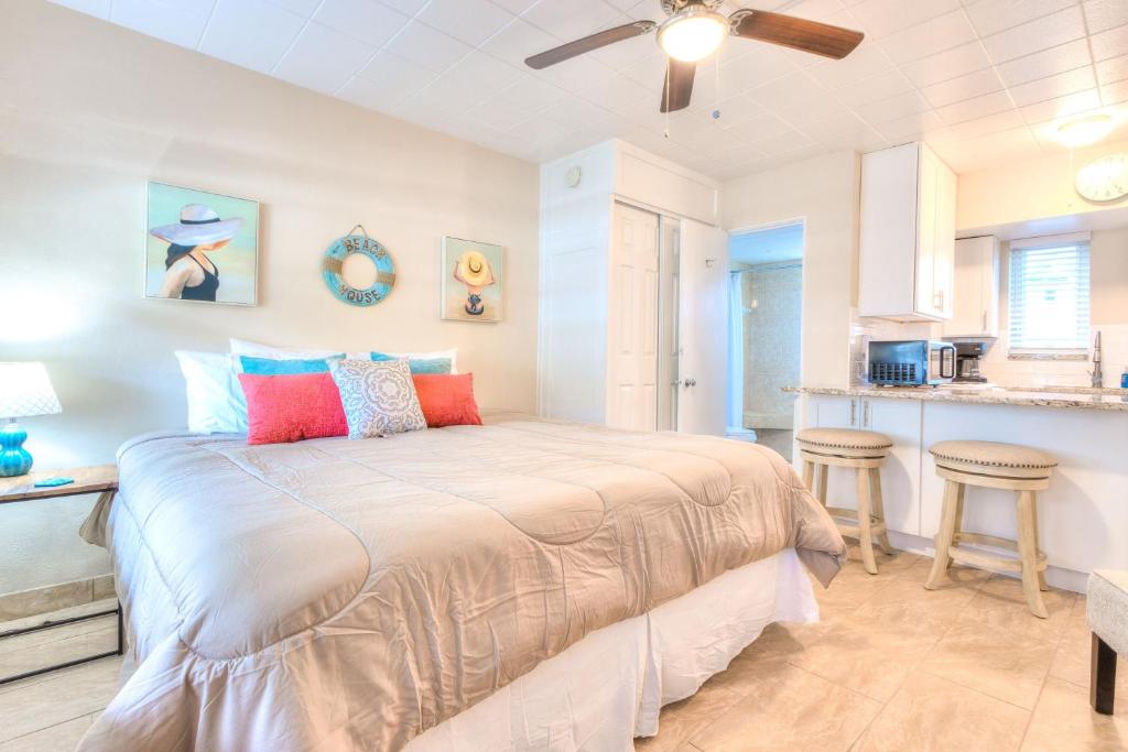 1 dormitorio con 1 cama y cocina en Tropic Terrace #18 - Beachfront Rental condo, en St Pete Beach