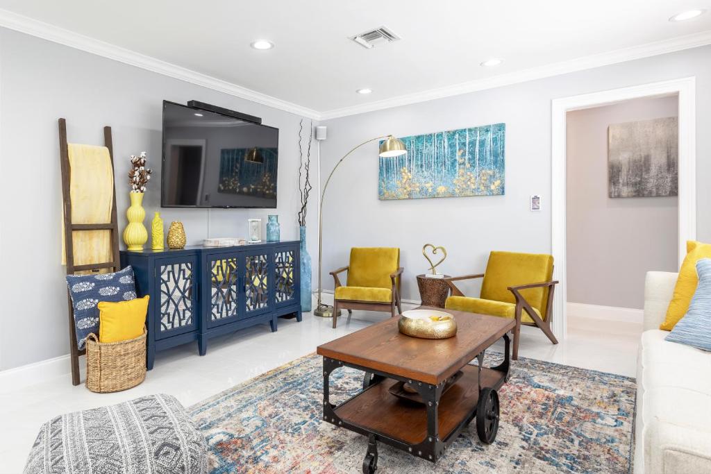uma sala de estar com cadeiras amarelas e uma mesa em Amazing! 3br 2ba Sofa Bed, Near Beach, Heated Pool, Full Kitchen, WiFI, Patio, BBQ, Private Yard, Peaceful Neighborhood em Fort Lauderdale