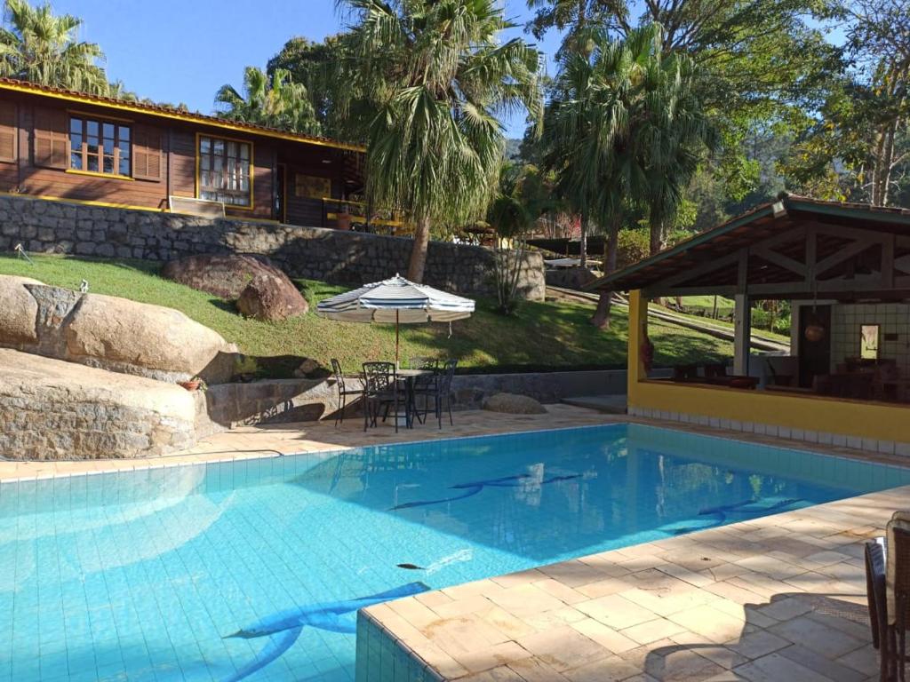 a swimming pool in front of a house at Belas Águas Mairiporã in Mairiporã