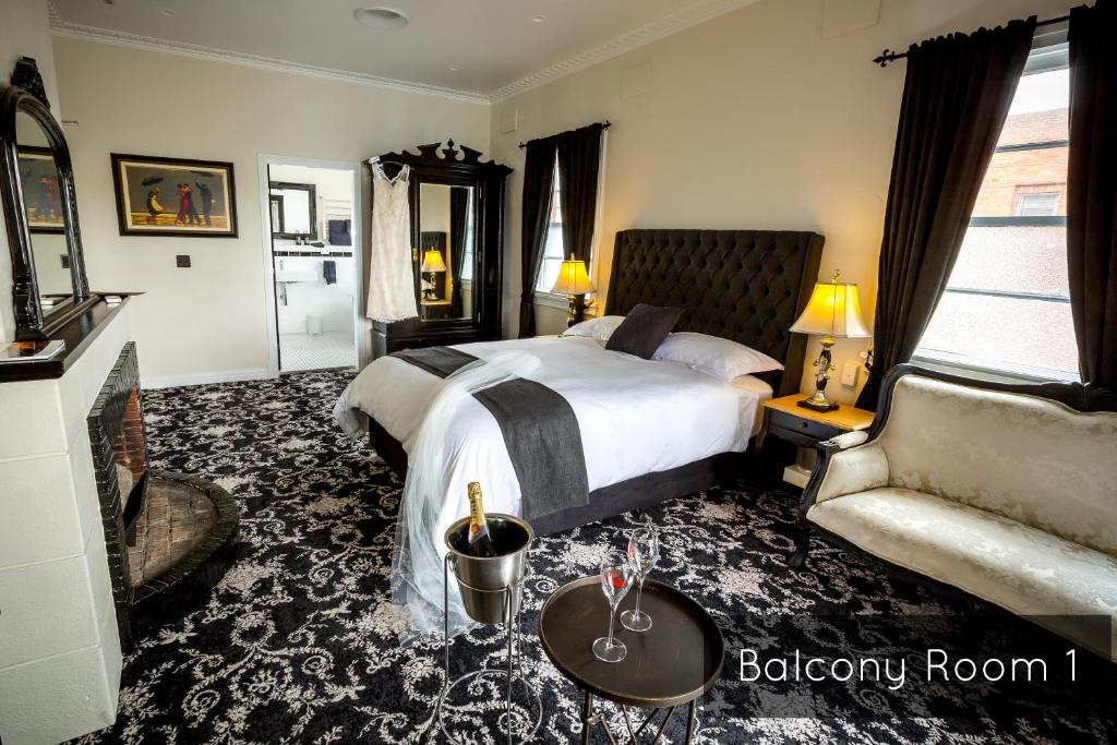 a hotel room with a bed and a couch at The Commercial Boutique Hotel in Tenterfield