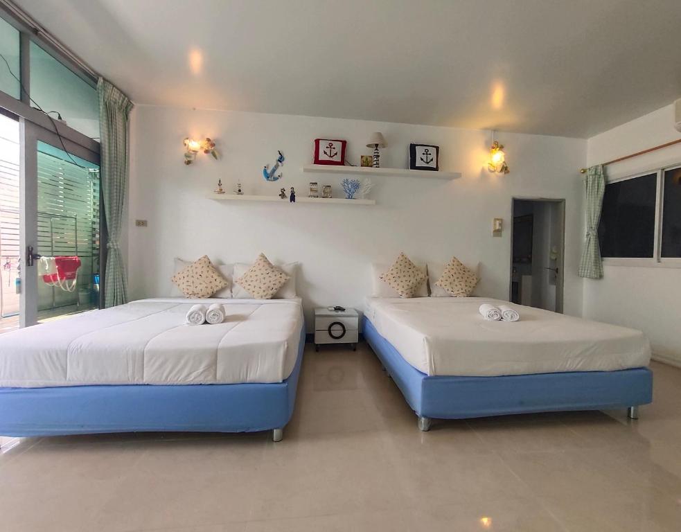 two beds in a room with two bedsitures at ฟ้าทะลายโจรรีสอร์ท in Prachuap Khiri Khan