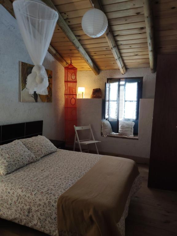 een slaapkamer met een bed en een raam bij Casa Rural El Trepador Azul in Cabeza la Vaca