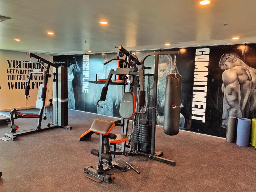 A compact gym combines resistance equipment with boxing bags.