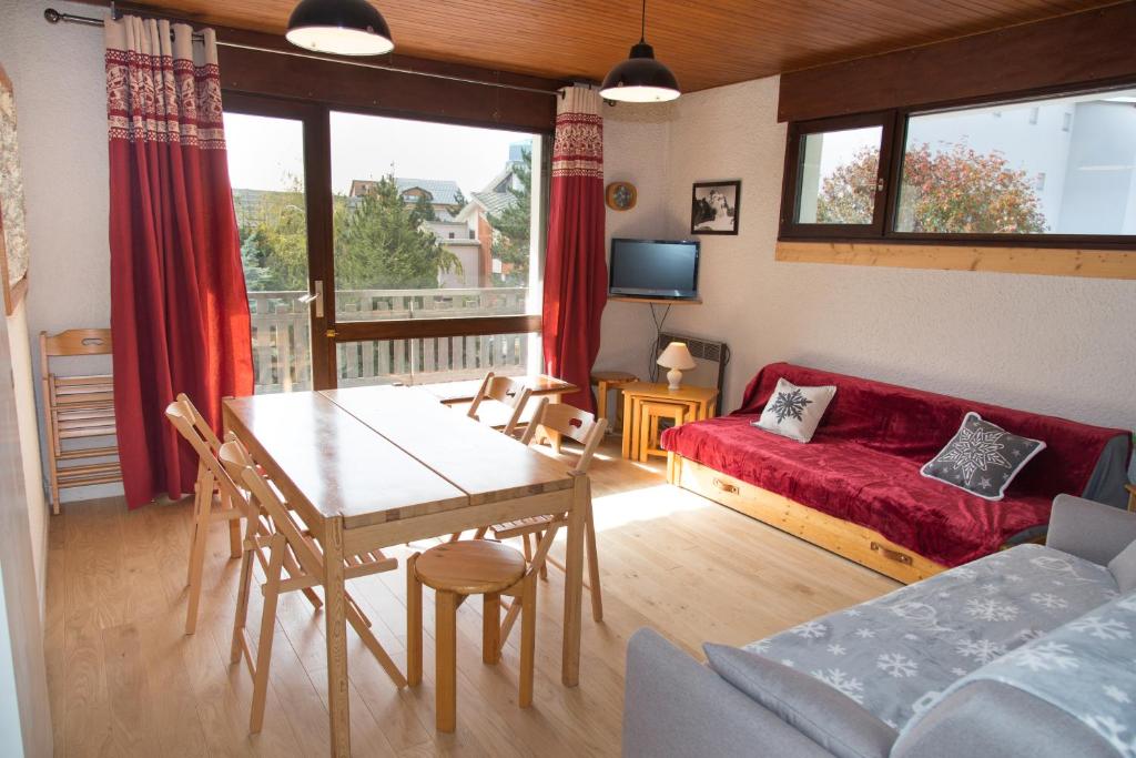 sala de estar con mesa y sofá en JANDRI 4 Appartement 6 personnes -38860 Les 2 Alpes - Pied des pistes, en Les Deux Alpes
