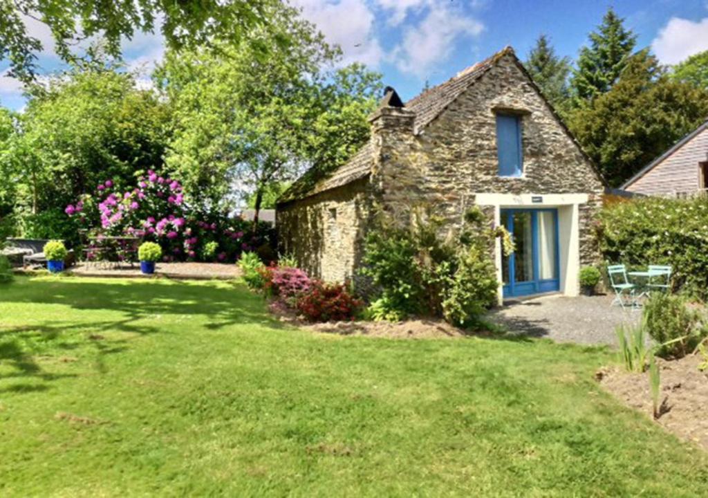 an old stone house with a yard at Hayloft at Kergudon Gîtes, Couples' gîte with pool in Sizun