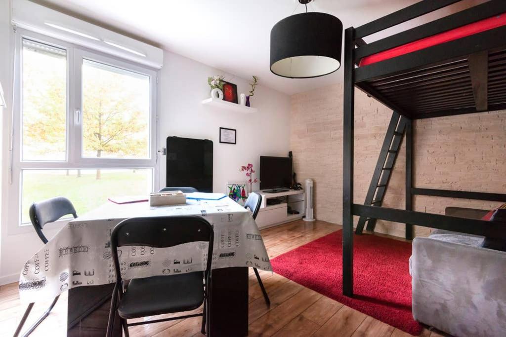 Cette chambre comprend une table et une mezzanine. dans l'établissement Nice Studio Near Mickey, Disneyland at 5mn, à Montévrain