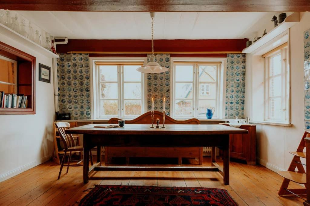 a kitchen with a large table in the middle of a room at Altes Fährhaus - Ferienwohnung Unnern, 170 qm in Wewelsfleth