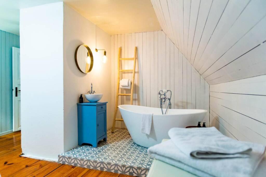uma casa de banho com uma banheira branca e um lavatório. em Altes Fährhaus - Ferienwohnung Boven, 220 qm em Wewelsfleth