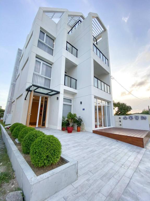 a white building with a courtyard in front of it at 墾丁山風足跡 in Kenting
