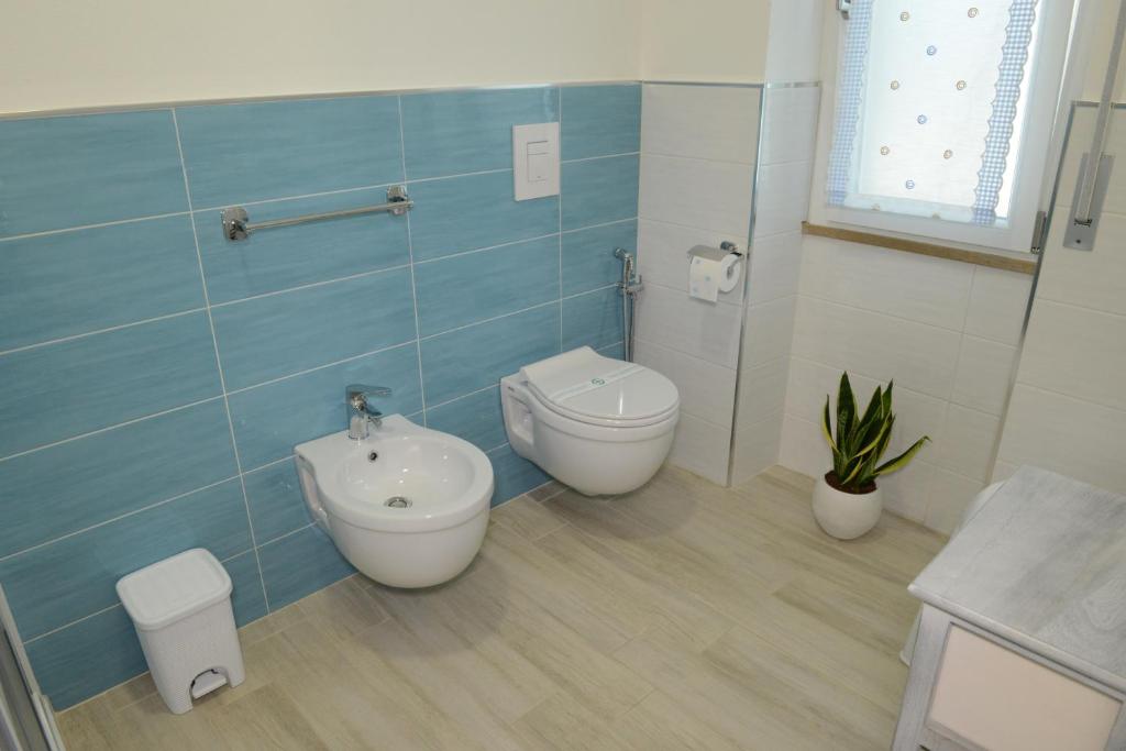 łazienka z toaletą, bidetem i umywalką w obiekcie B&B LaMarina w mieście Alghero