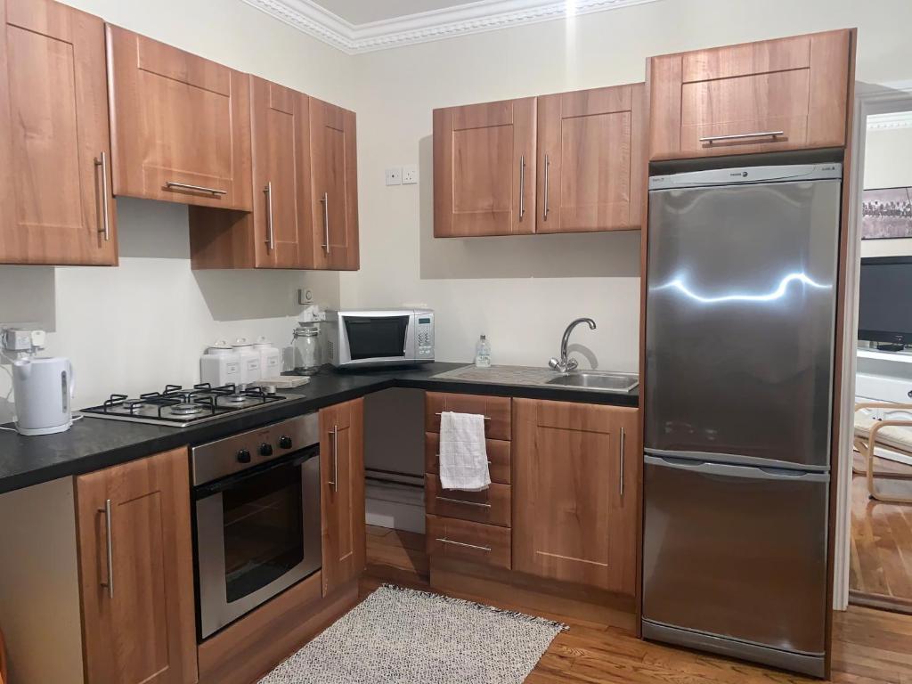 a kitchen with wooden cabinets and a stainless steel refrigerator at Carraig House in Cavan