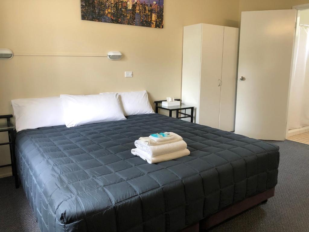 a bedroom with a bed with a towel on it at Fairway Lodge Motel in Kempsey