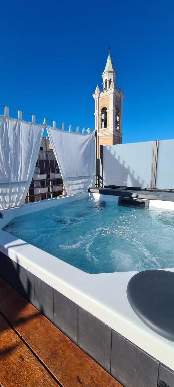 a hot tub on the roof of a building with a clock tower at Terrazze Caracciolo in Pescara