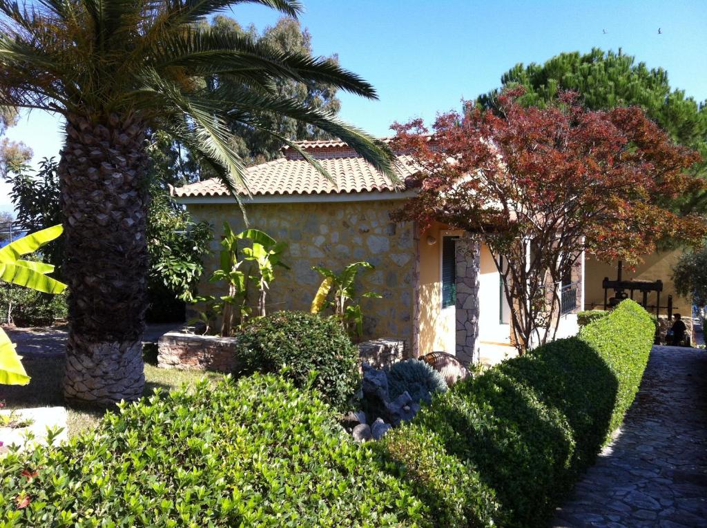 una casa con una palmera y algunos arbustos en 9 Muses Villas, en Chrani