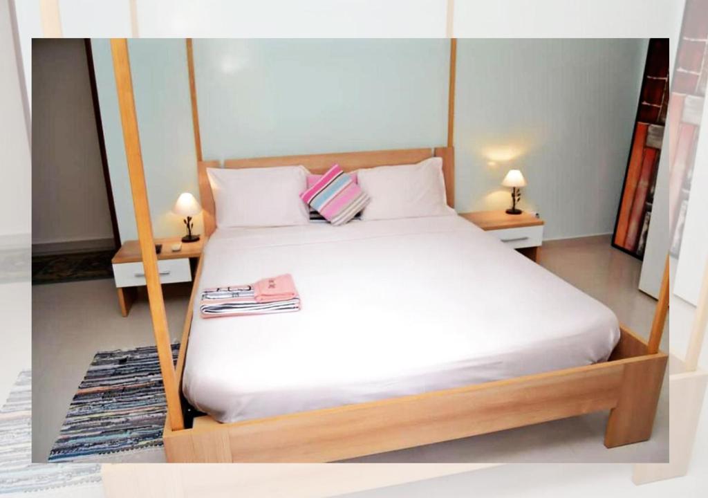 a bedroom with a white bed with two night stands at Chez Ouly in Dakar