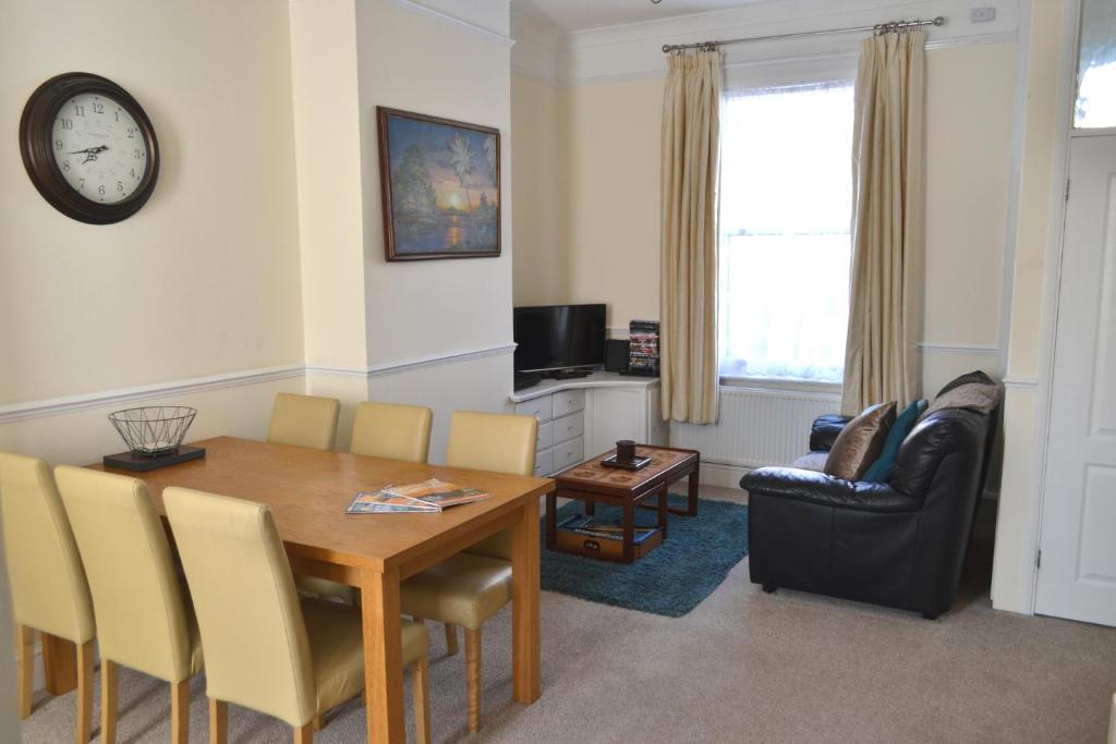 a living room with a dining room table and a couch at Seam Terrace - Home from Home in Sittingbourne