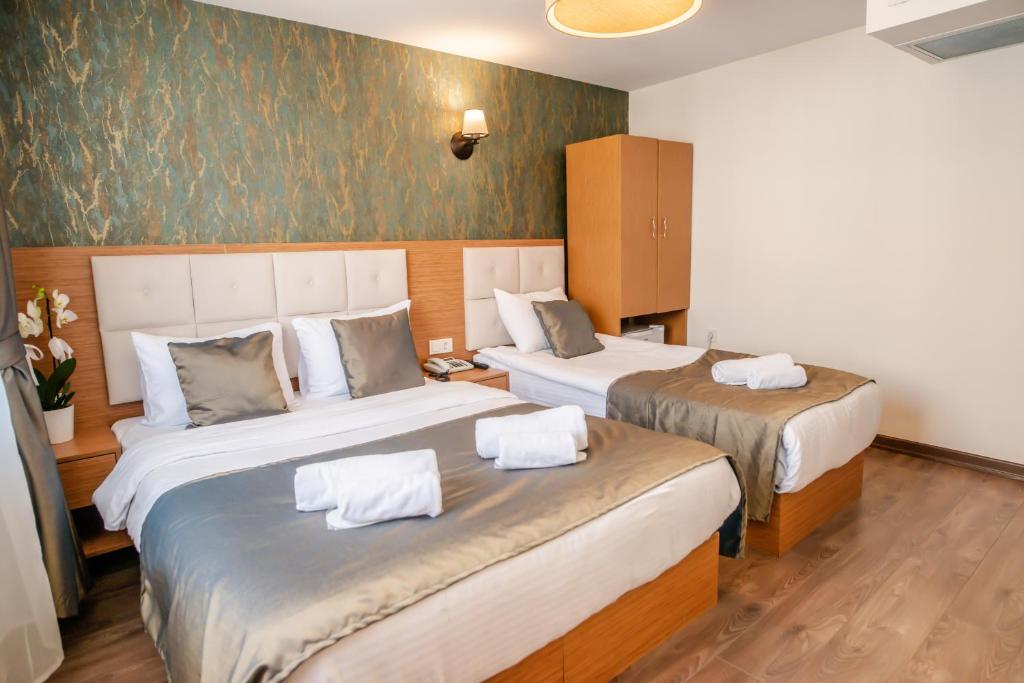 Postel nebo postele na pokoji v ubytování The Camelot Hotel