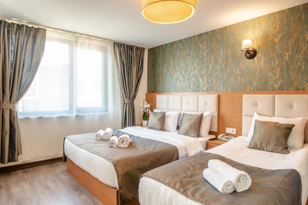 Postel nebo postele na pokoji v ubytování The Camelot Hotel