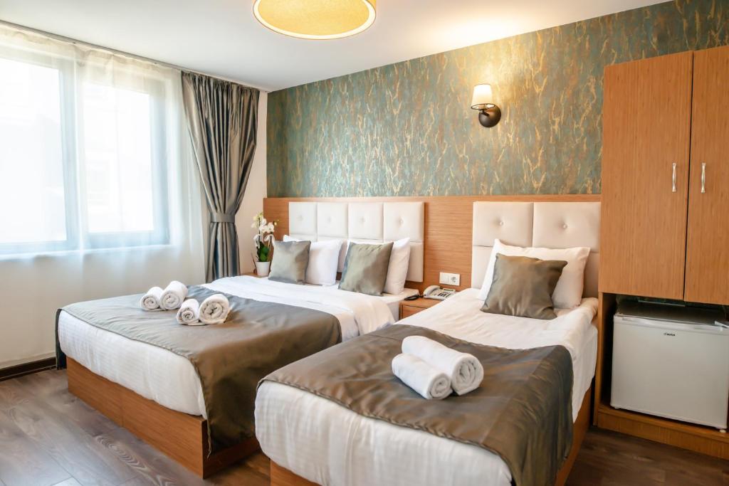 Postel nebo postele na pokoji v ubytování The Camelot Hotel