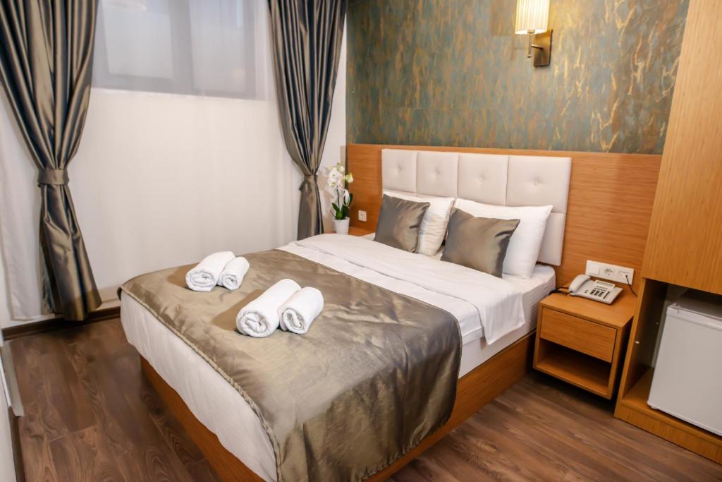 Postel nebo postele na pokoji v ubytování The Camelot Hotel