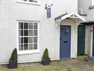 una casa bianca con una porta blu e una finestra di Upside Down Cottage a Richmond