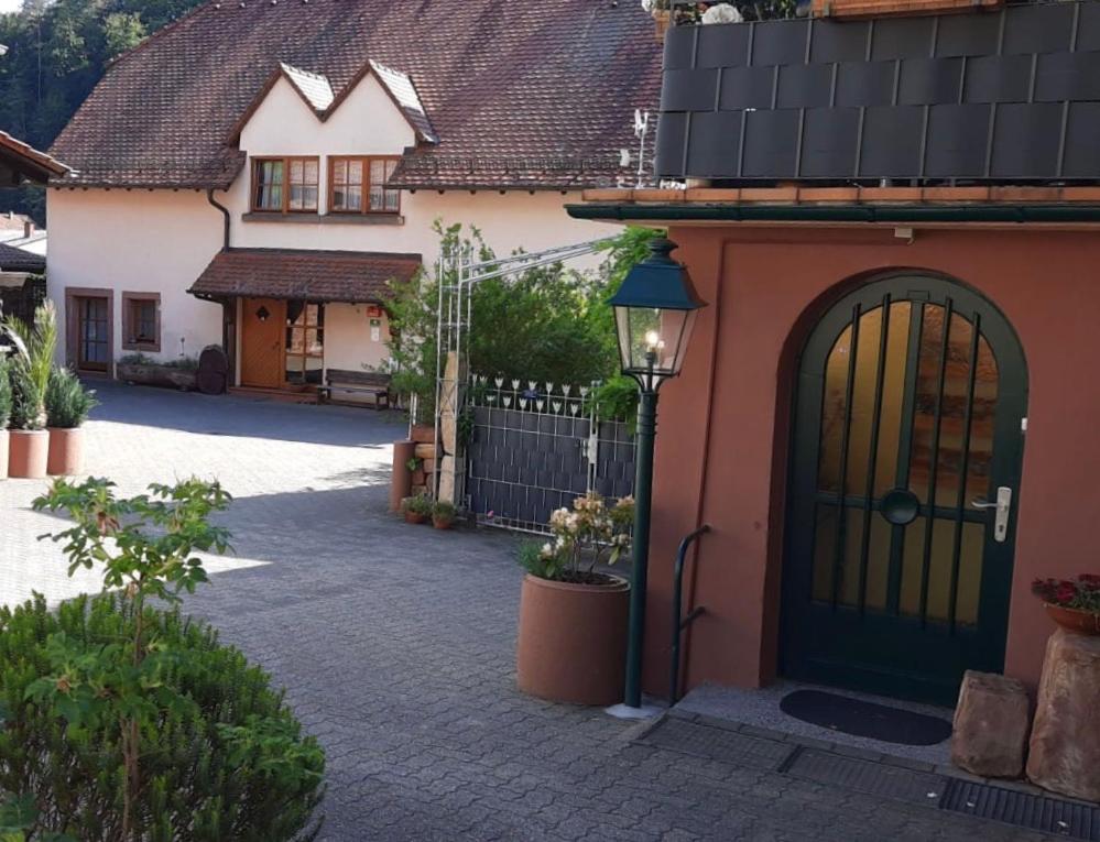 a house with a black door and a street light at Pension - Gästehaus Zum Pfälzerwald in Hinterweidenthal