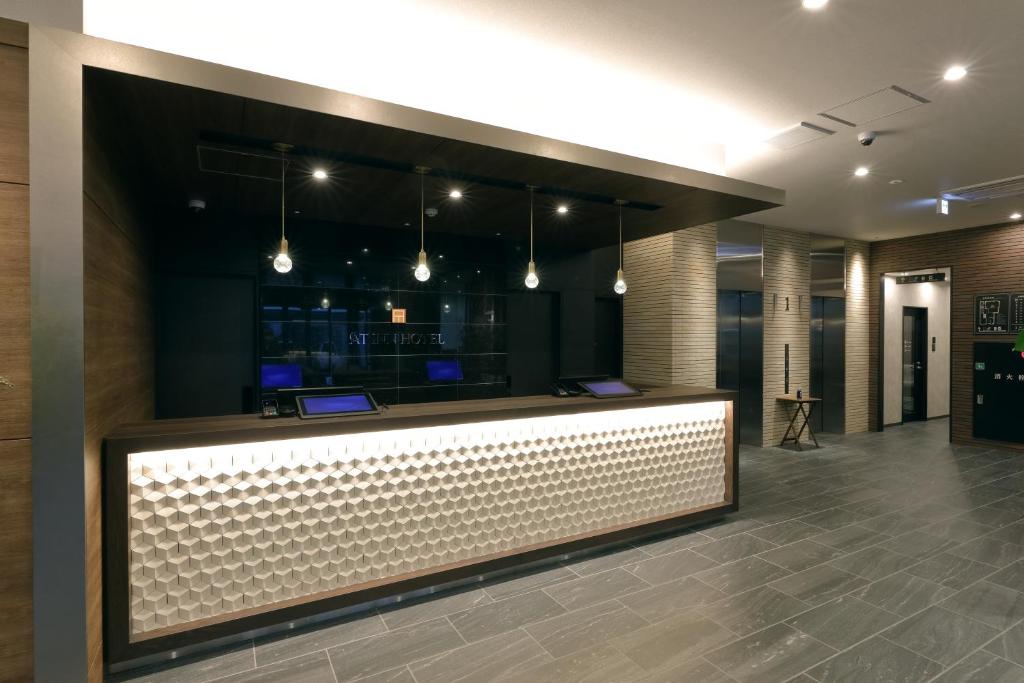 eine Lobby mit einer Bar in einem Gebäude in der Unterkunft At Inn Hotel Toyotashi Eki in Toyota