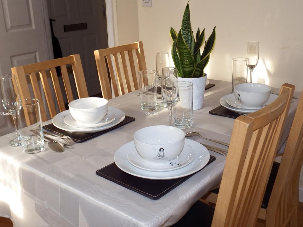 una mesa con platos, tazones y vasos. en Amama's Cabin, en Great Yarmouth