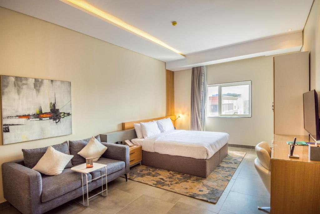 ジッダにあるEwaa Express Hotel - Al Rawdaのベッドとソファのあるホテルの部屋